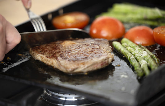 Miljöbild  skär i en biff direkt på stekbordet