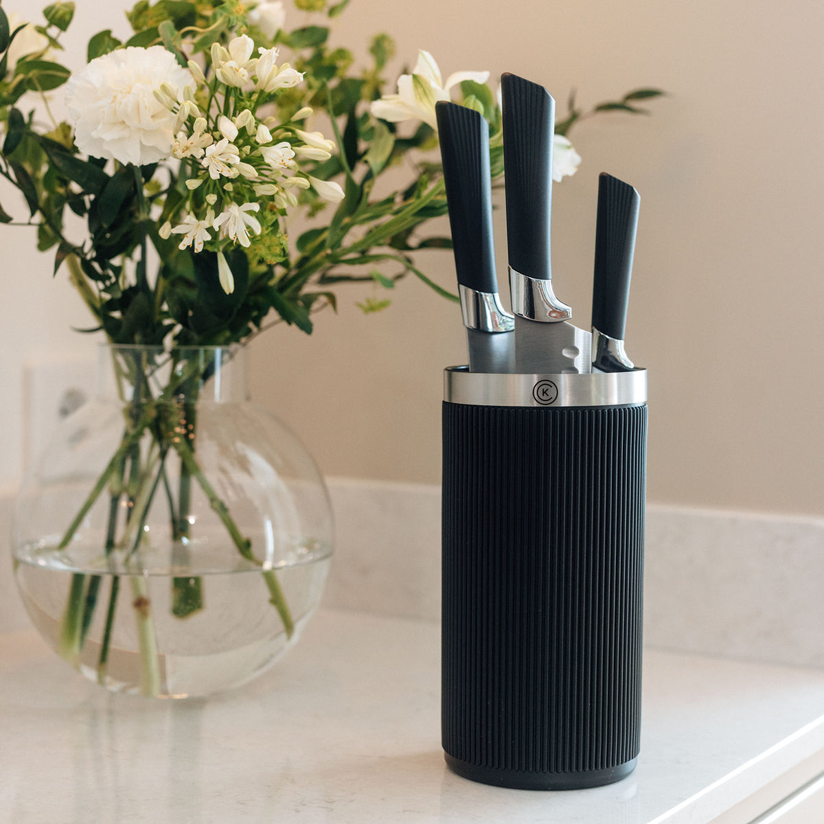 Svart Catarina König Master Core knivställ med tre knivar på köksbänk bredvid blommor