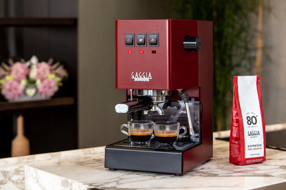Miljöbild Gaggia Classic E24 espressomaskin på bänk med espressokoppar och en påse kaffe