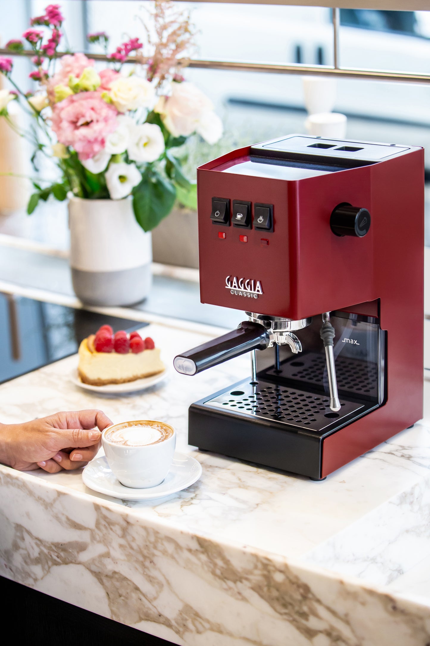 Miljöbild Gaggia Classic E24 espressomaskin i röd på bänk med cappuccino och bakelse